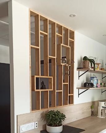 Paravent en bois avec étagères, intégré à un mur blanc.