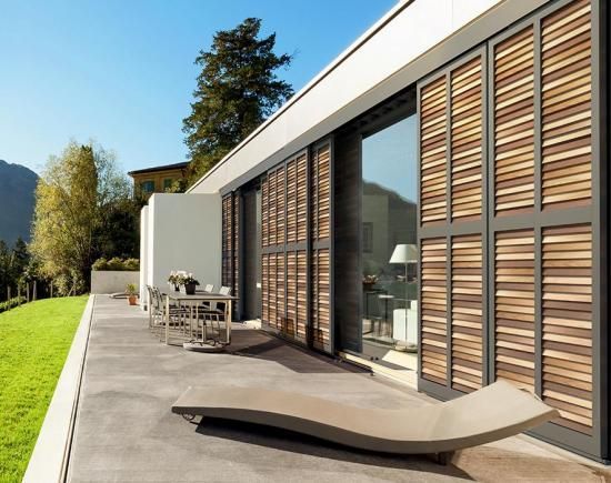 Grands volets coulissants en aluminium et bois pour les portes-fenêtres