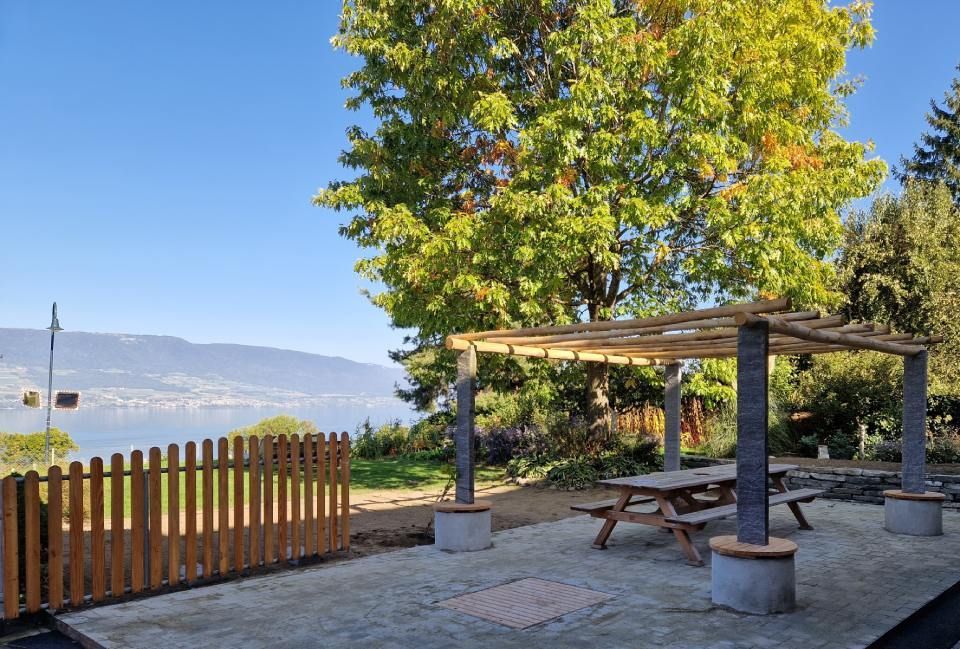 Une pergola en bois avec une table de pique-nique en dessous réalisé par des jardiniers professionnels.