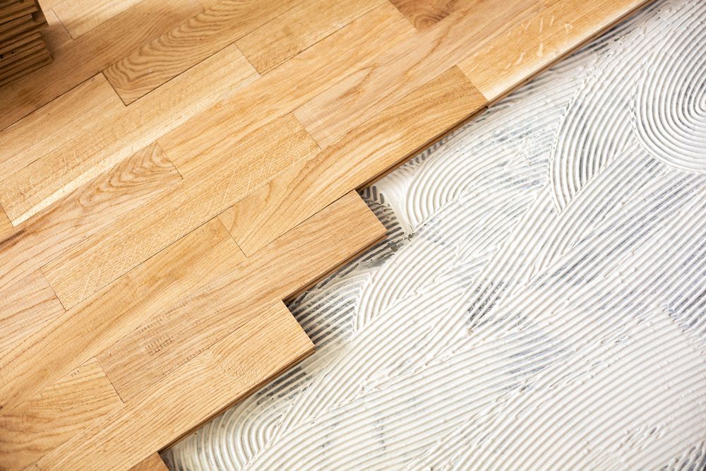 Un primer plano de un piso de madera en proceso de instalación.