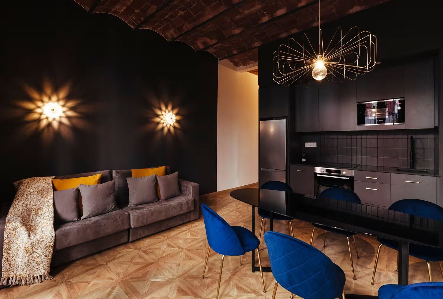 Una sala de estar con sofá, mesa, sillas y una cocina.