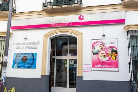 El frente de un edificio con un cartel rosa encima de la puerta.