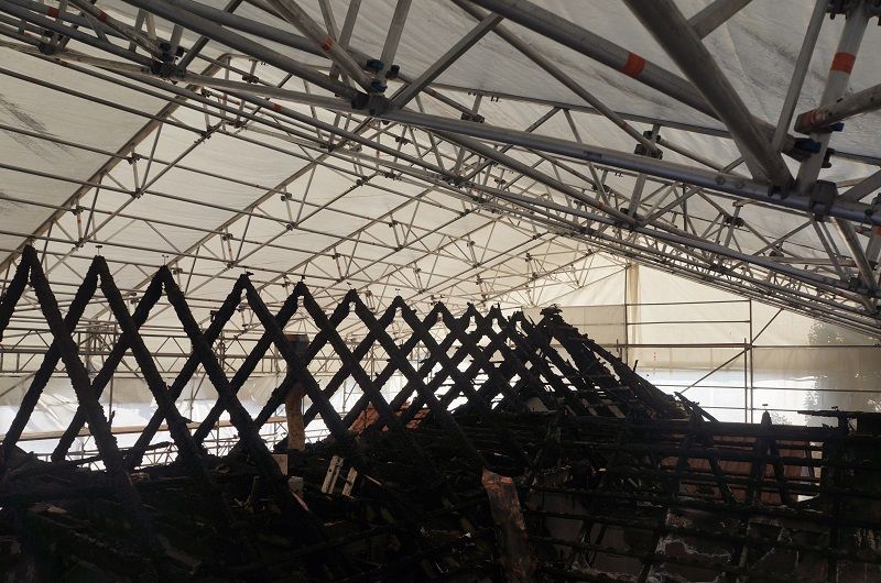 Ein großes Gebäude mit einem Dach, das mit einer weißen Plane bedeckt ist.