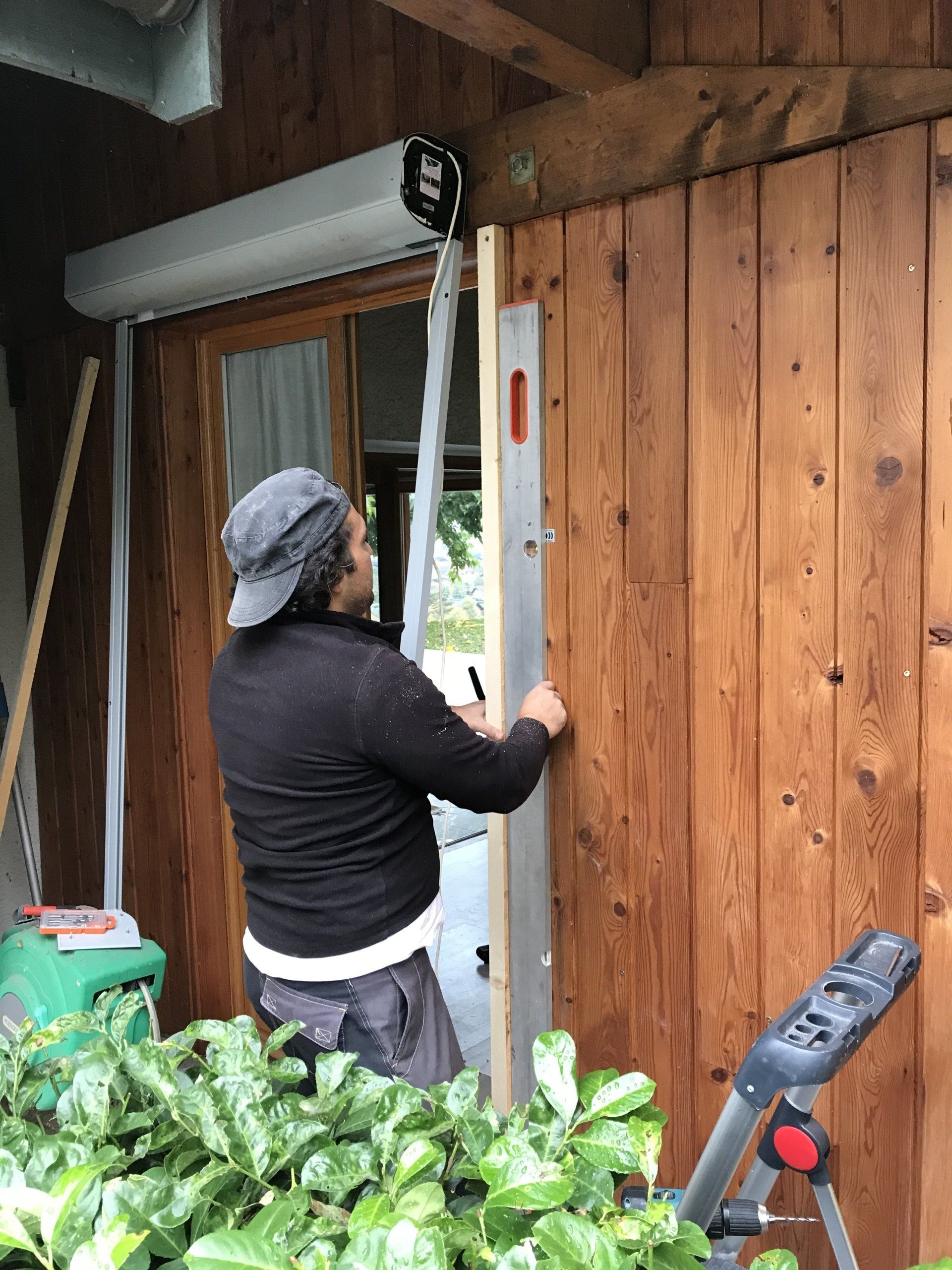 Un homme installe des volets roulants