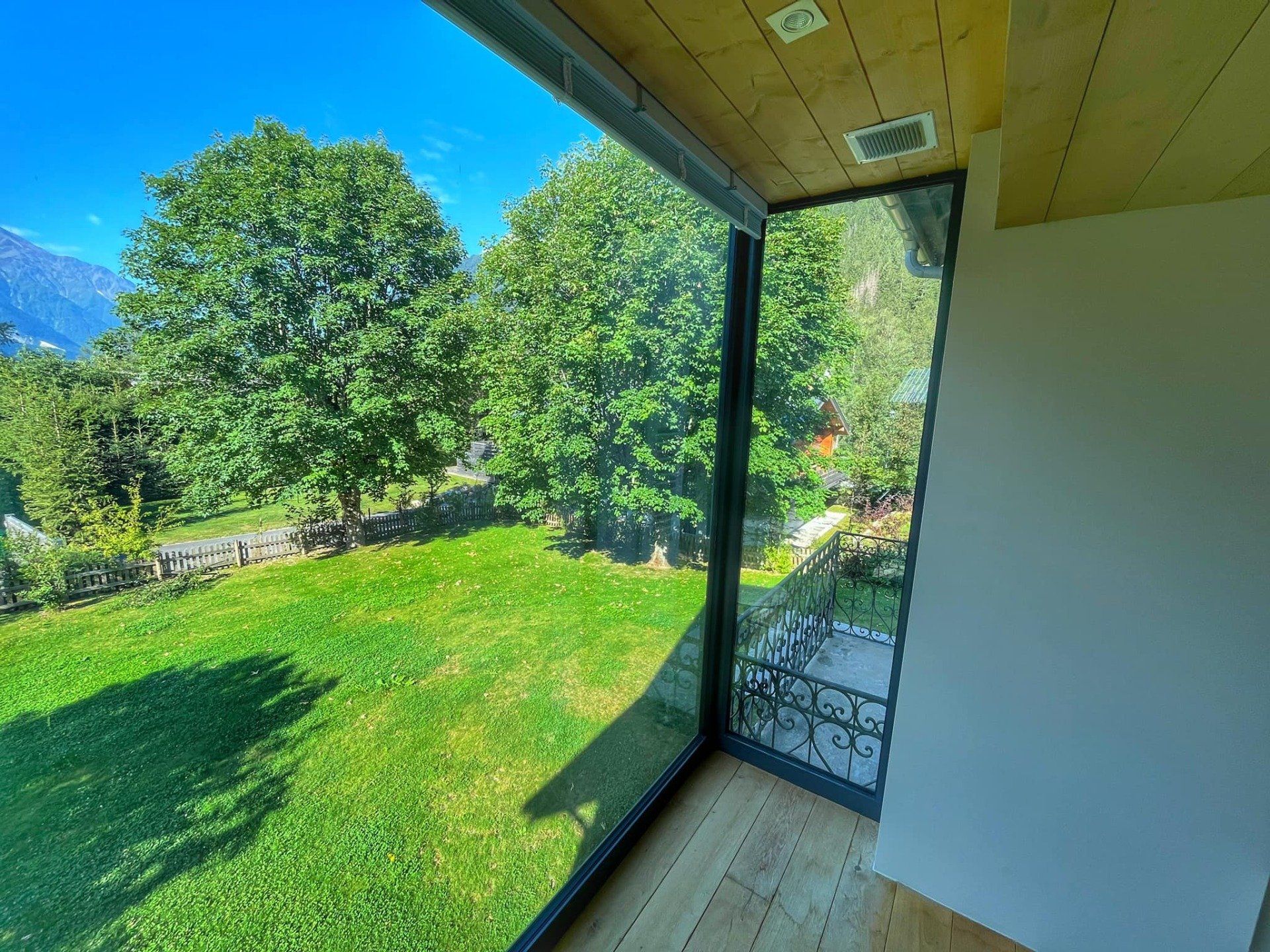 Baie vitrée en aluminium donnant sur un jardin arboré