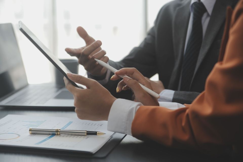 Personen diskutieren am Schreibtisch