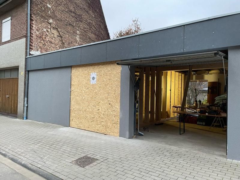 An der Seite eines Gebäudes wird ein Garagentor eingebaut.