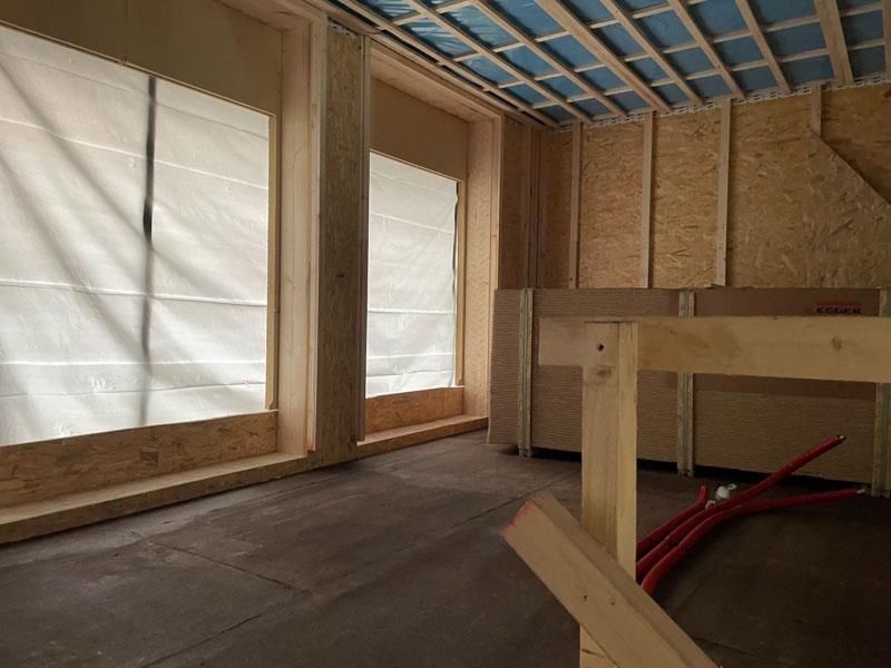 Ein Raum mit vielen Fenstern und einer Treppe im Hintergrund