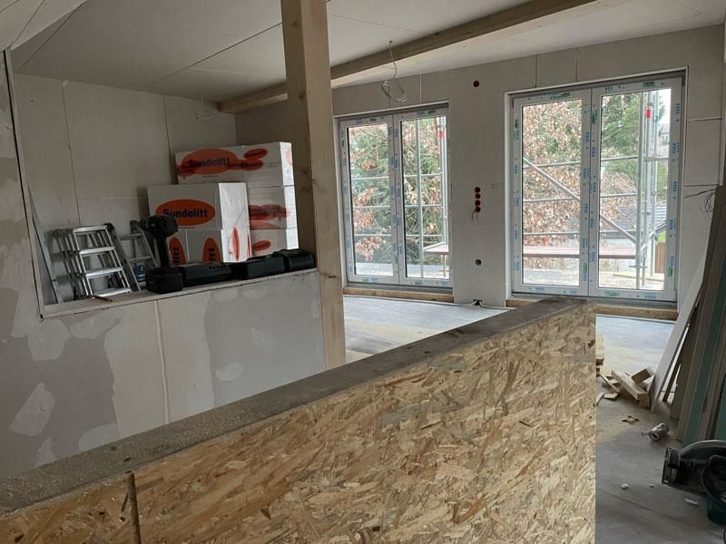 Ein Raum mit einer Holzwand und vielen Fenstern.