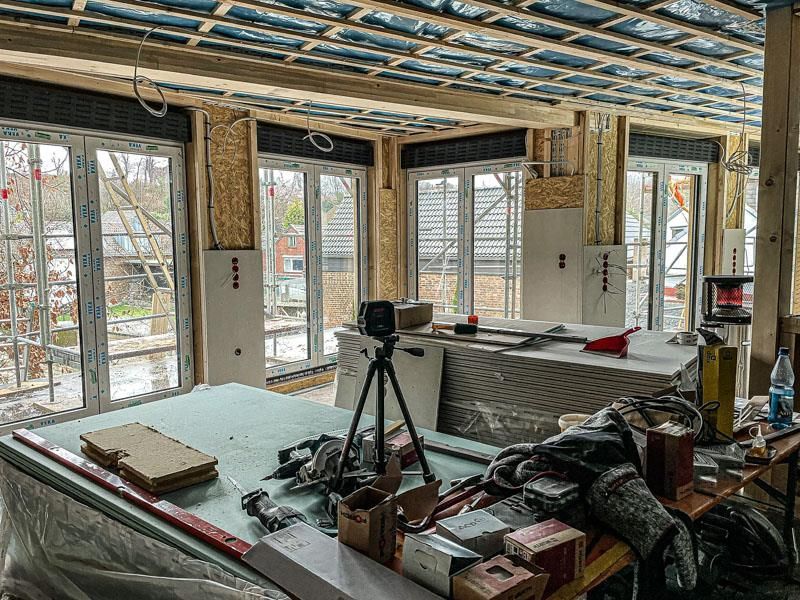 Ein im Bau befindlicher Raum mit vielen Fenstern und einer Kamera auf einem Stativ.