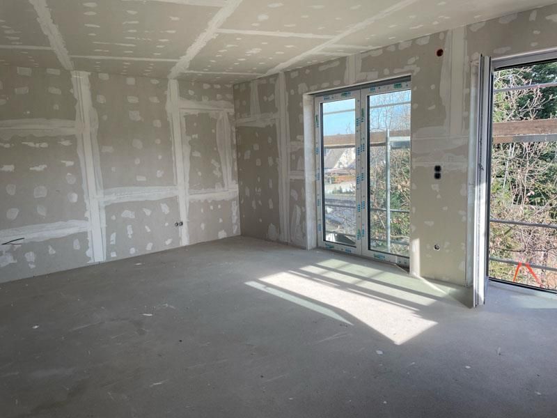 Ein leerer Raum mit einer Glasschiebetür und einem Fenster.