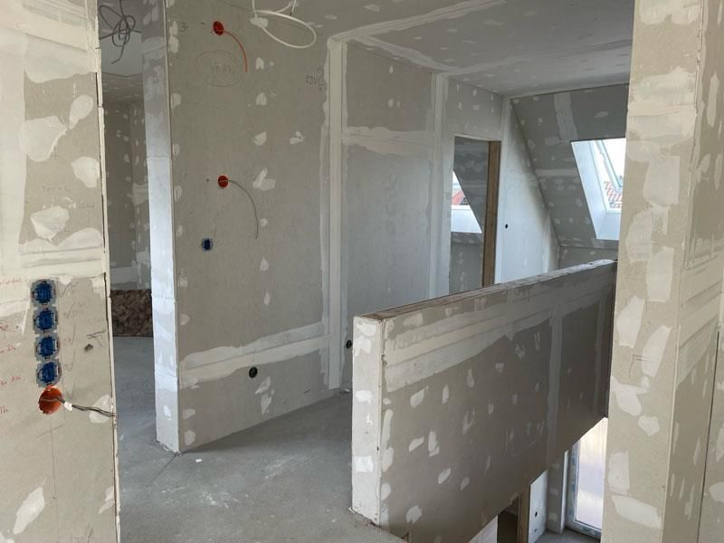 Ein Raum mit viel Gipskarton an den Wänden und einem Fenster.