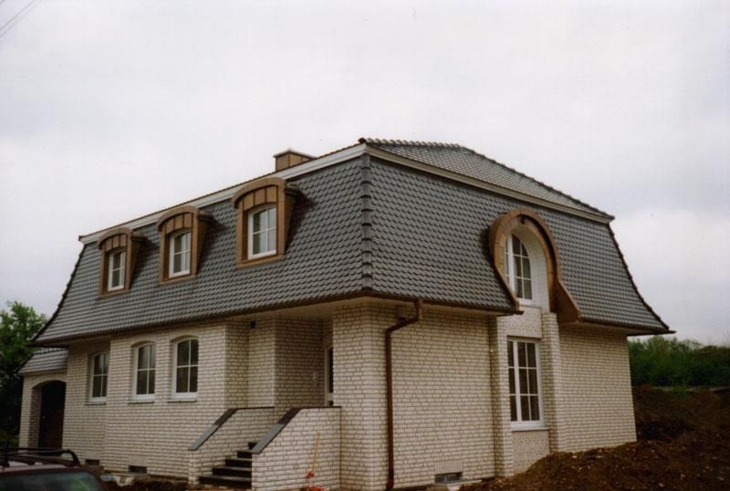 Ein weißes Haus mit Schieferdach und Bogenfenstern