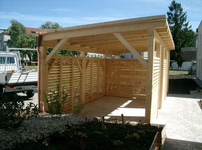 Ein weißer LKW steht vor einer Holzkonstruktion