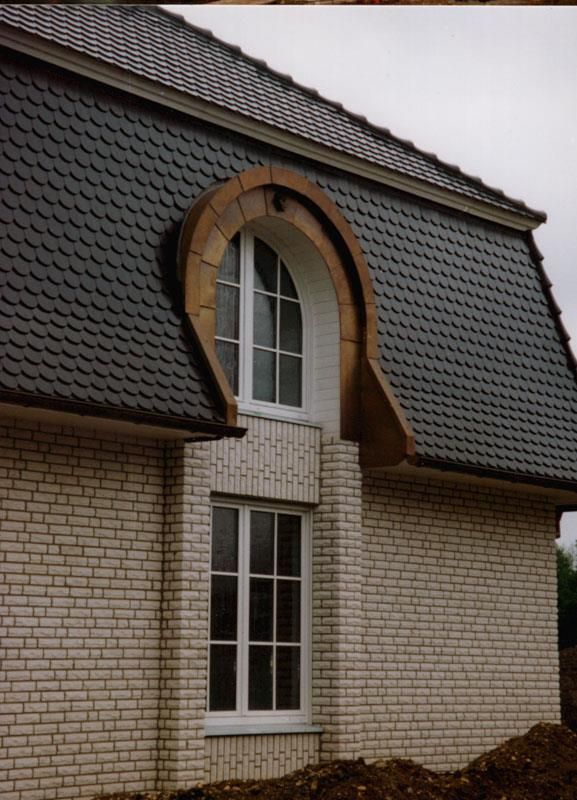 Ein weißes Backsteingebäude mit Schieferdach und Fenster