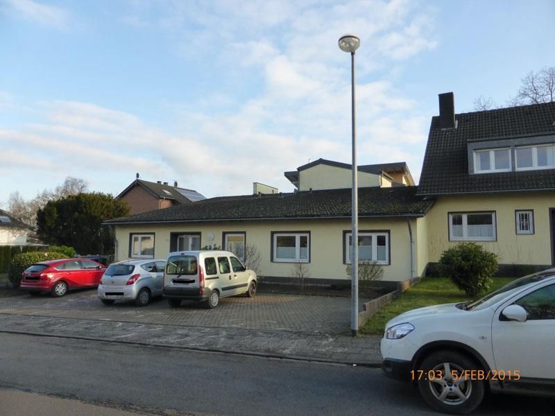 Ein weißer Geländewagen steht vor einem gelben Gebäude