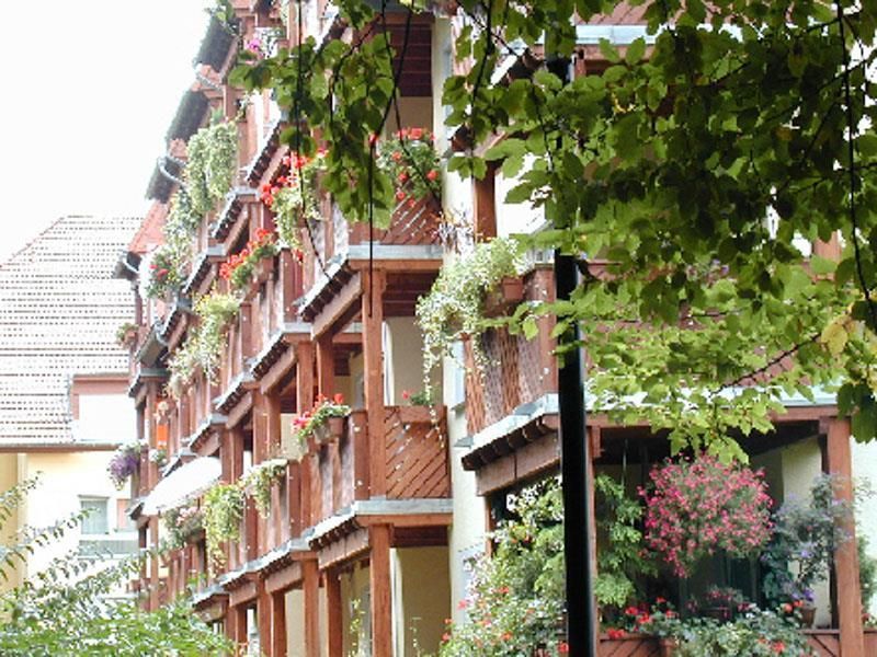 Ein Gebäude mit vielen Balkonen und Blumen darauf