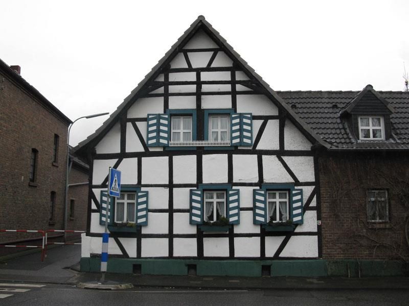 Ein weiß-schwarzes Haus mit grünen Fensterläden