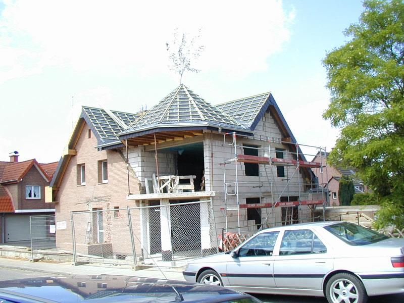 Ein Auto steht vor einem im Bau befindlichen Haus