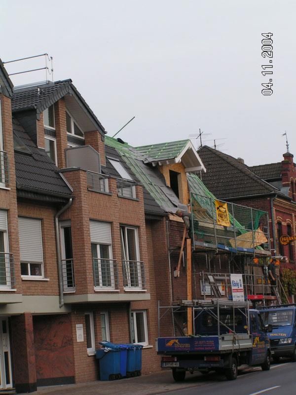 Eine Reihe von Backsteingebäuden mit einem davor geparkten blauen Lastwagen