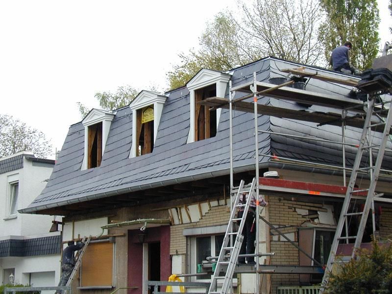 Ein Mann arbeitet auf dem Dach eines Hauses