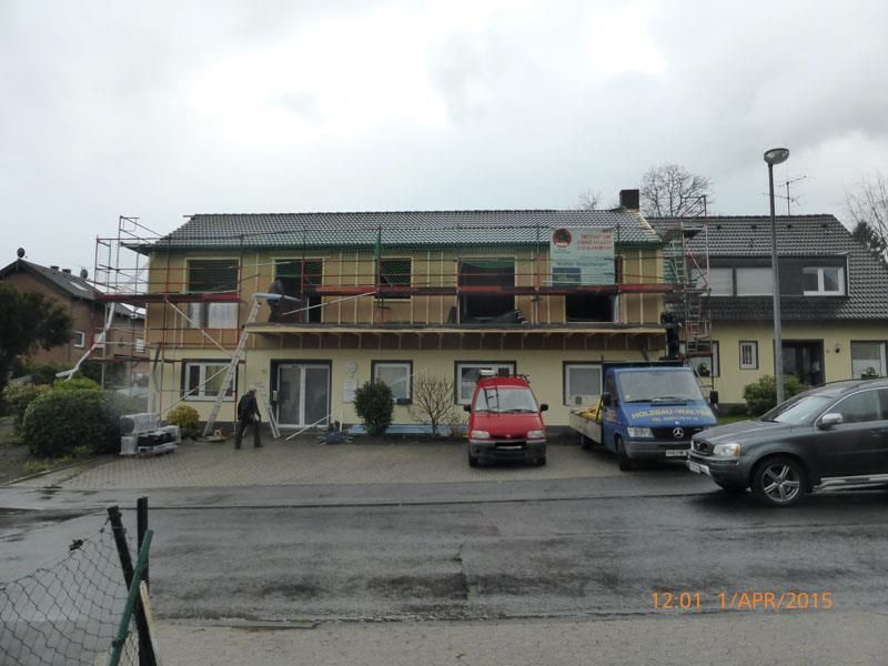 Ein im Bau befindliches Gebäude mit davor geparkten Autos