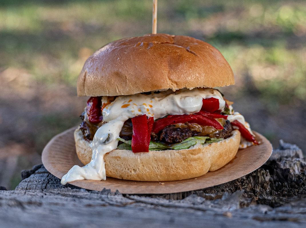 Hamburguesa con palillo, en plato pequeño, al aire libre.