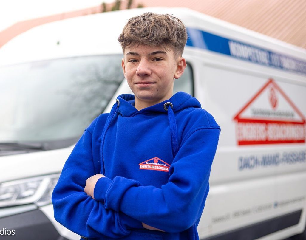 Ein junger Mann in einem blauen Kapuzenpullover steht vor einem weißen Lieferwagen