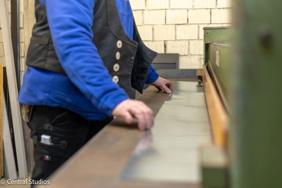 Ein Mann im blauen Hemd arbeitet an einer Maschine