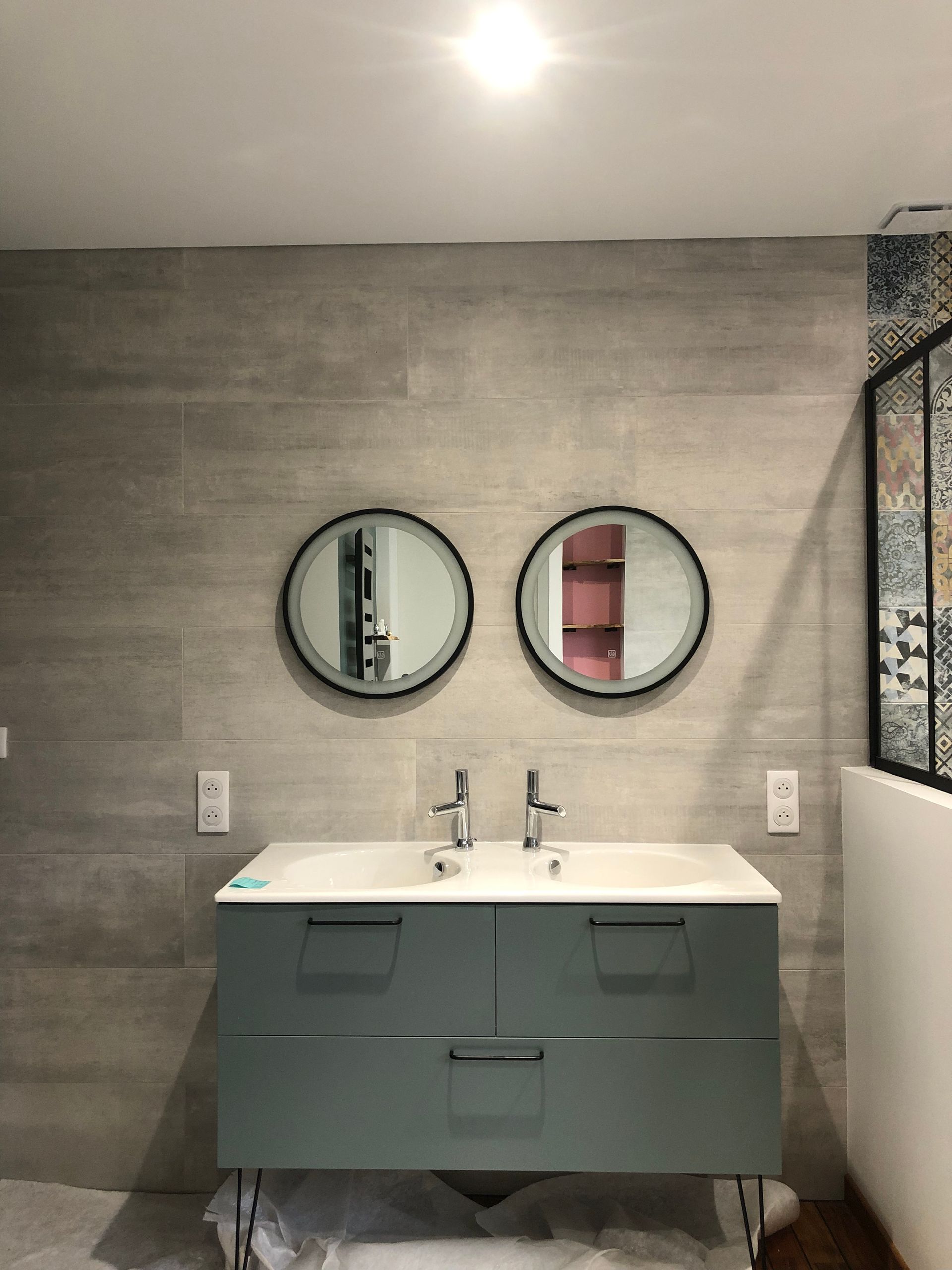 Salle de bains avec meuble vasque et deux miroirs ronds