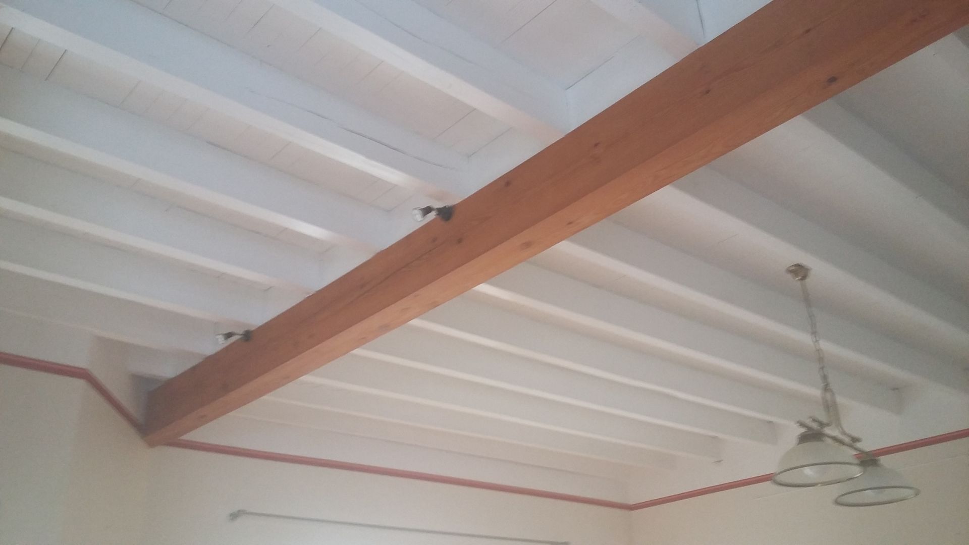 Un plafond vu du dessous avec une poutre au milieu