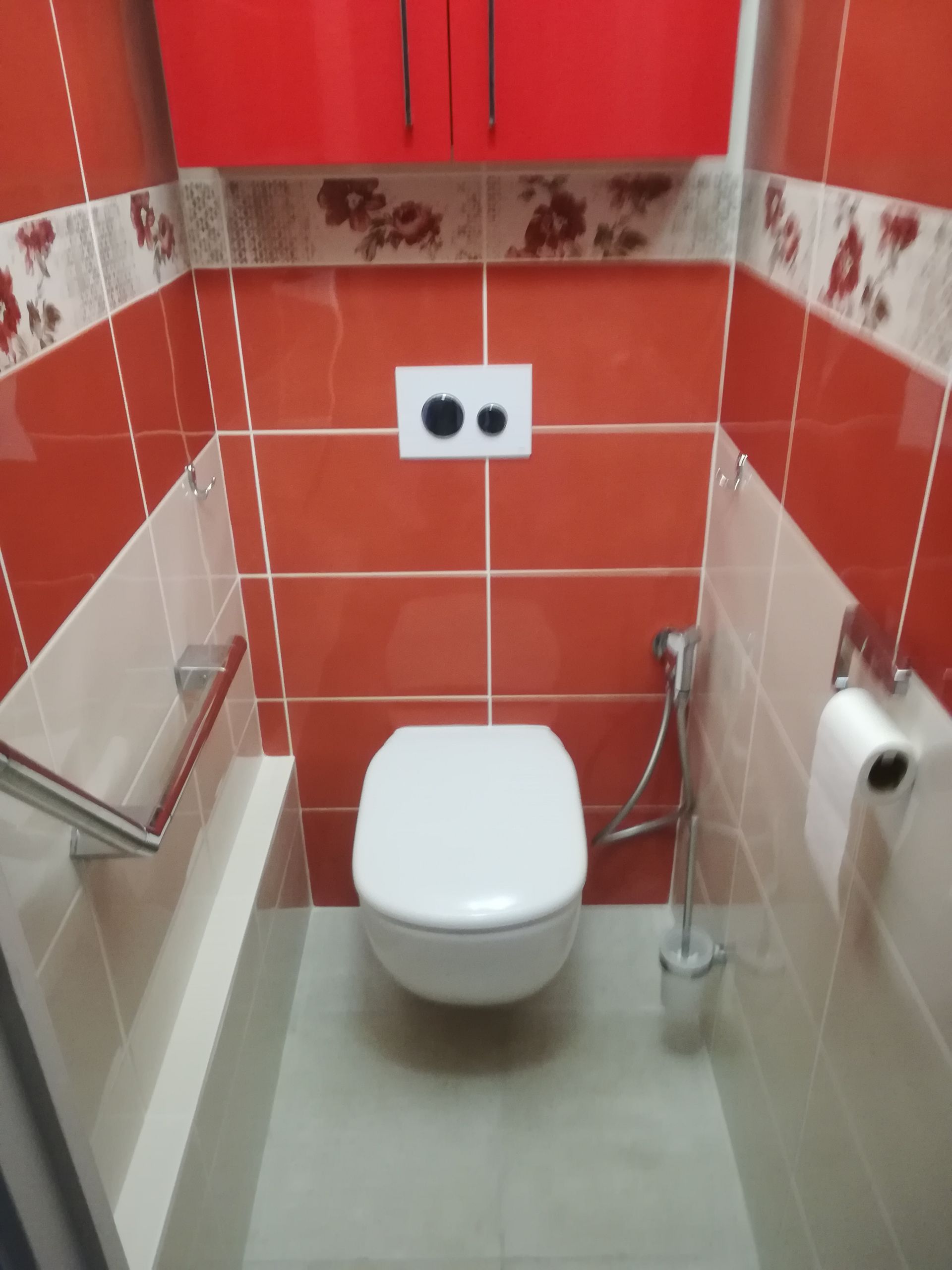 Une pièce aux murs rouges avec un WC au centre de la pièce