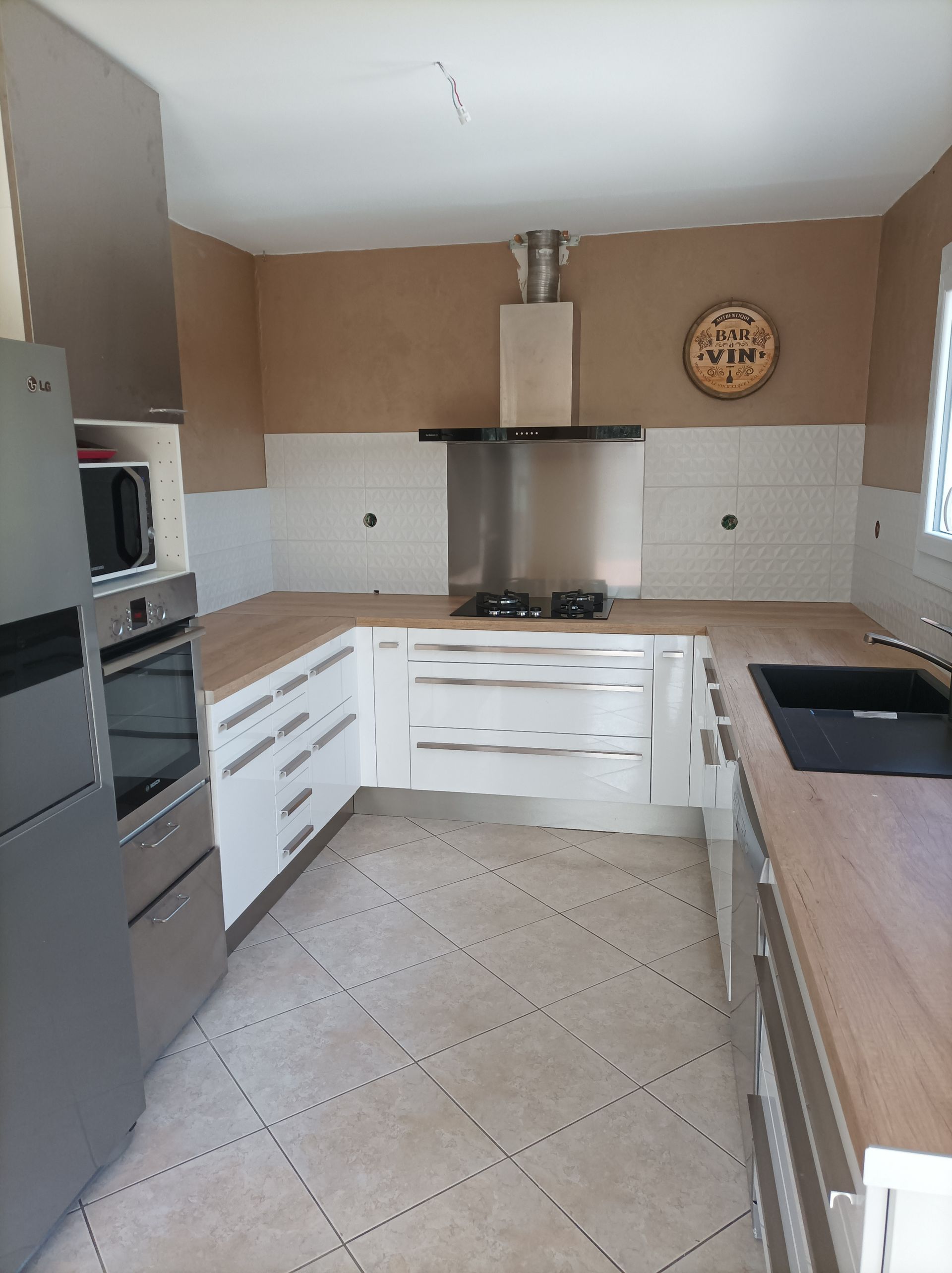 Un comptoir de cuisine en U et équipé d'électroménagers vu de face