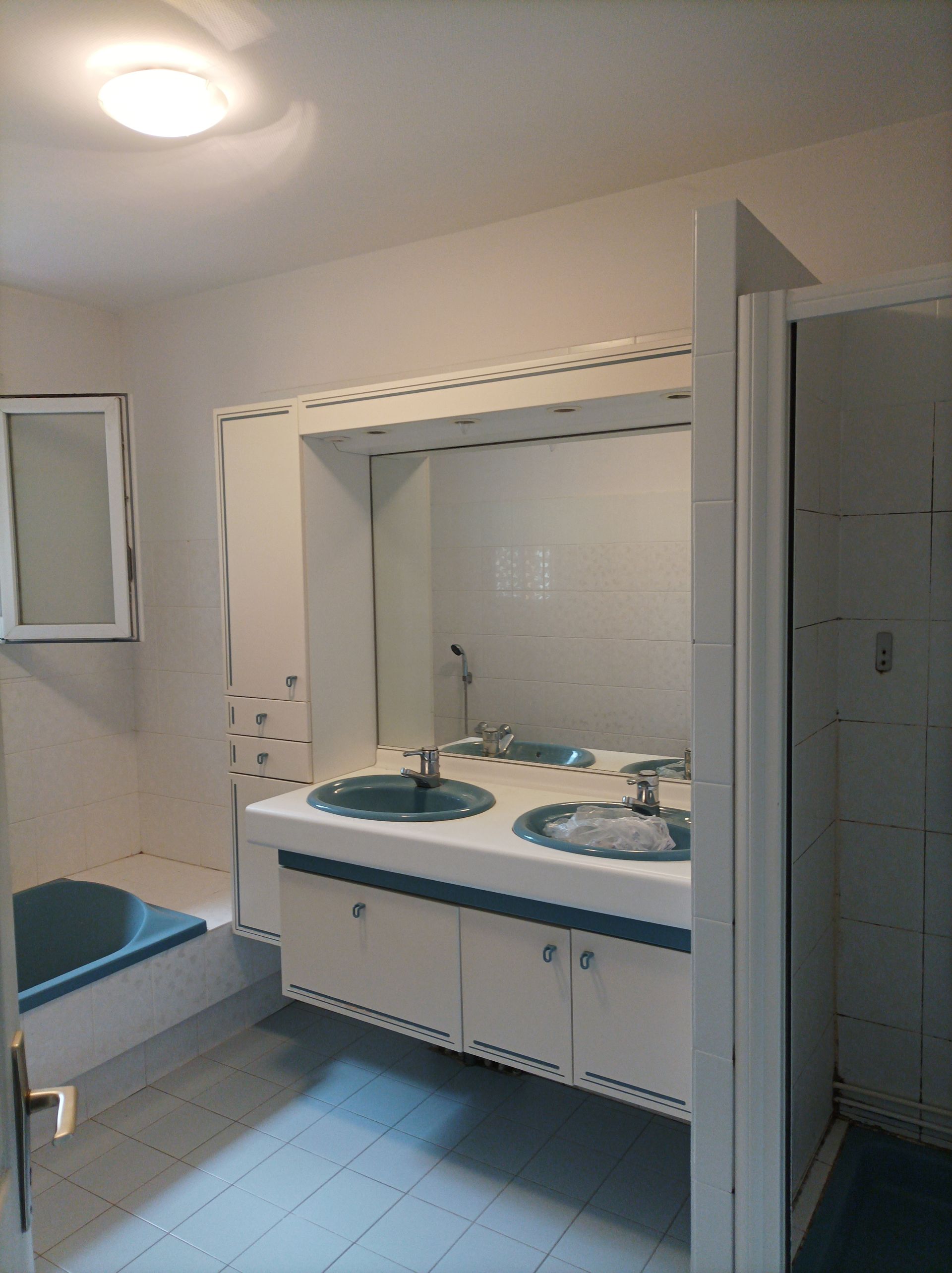 Deux lavabos et un miroir carré près d'une baignoire