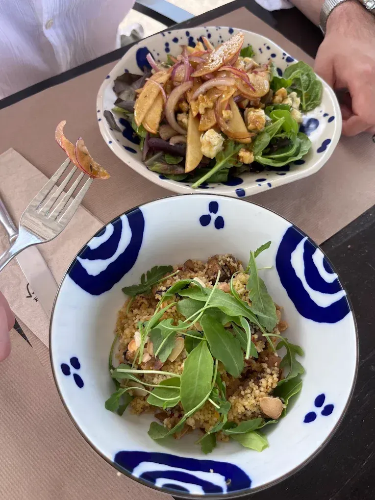 Hay dos tazones de comida sobre una mesa con un tenedor.