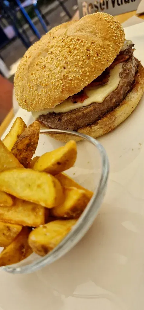 Un primer plano de una hamburguesa y papas fritas en una mesa.