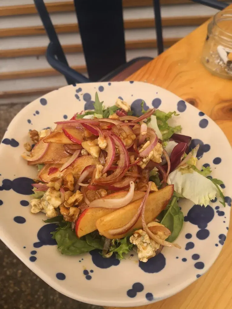 Un plato azul y blanco con una ensalada encima.