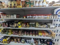 Regale in einem Lebensmittelgeschäft, gefüllt mit verschiedenen Lebensmitteln, darunter Gläser, Flaschen, Snacks und Gewürzbehälter.