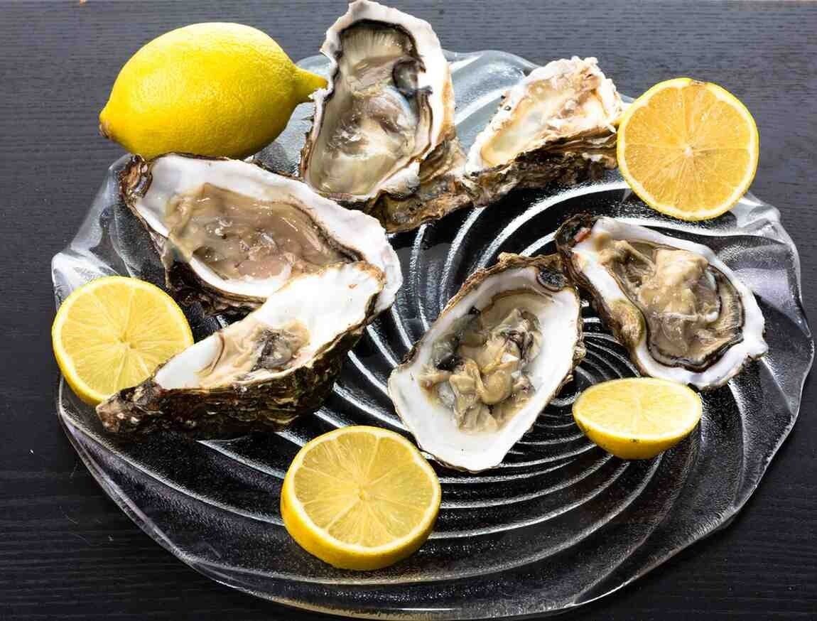 Pasteles fritos en una bandeja blanca con salsa para mojar, colocados sobre un mantel azul.