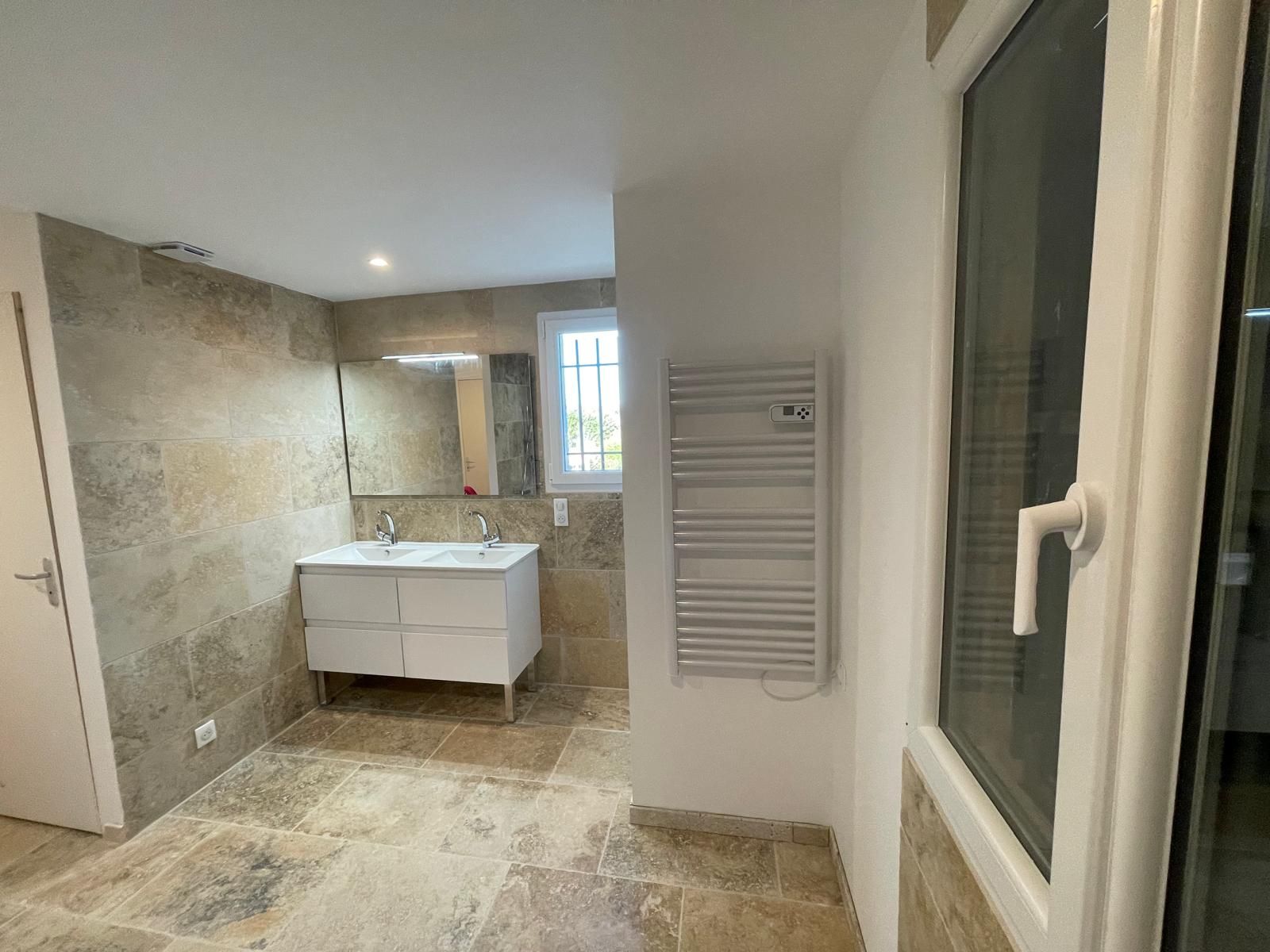 Plombier utilisant une clé pour connecter un tuyau d'eau à une vanne sur une surface en bois foncé.