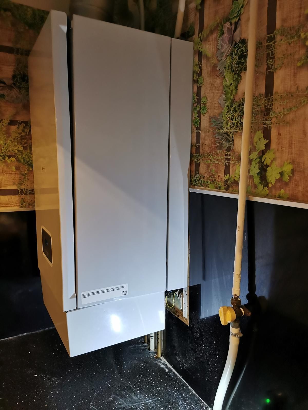 Mains dans des gants utilisant des pinces sur des tuyaux de plomberie.