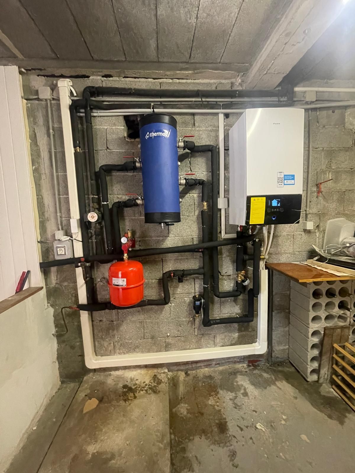 Robinetterie de salle de bain : lavabo, tuyauterie et baignoire blancs. Murs et sol couleur crème.