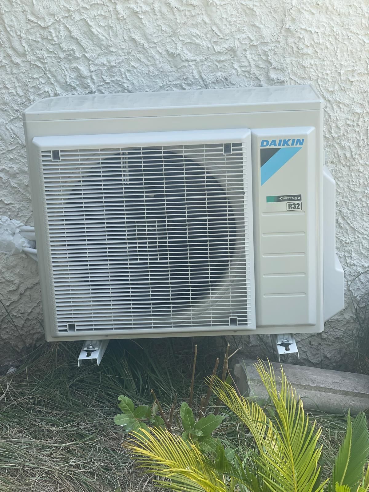 Mains dans des gants bleus retirant un filtre de climatisation, nettoyant l'appareil à l'intérieur.