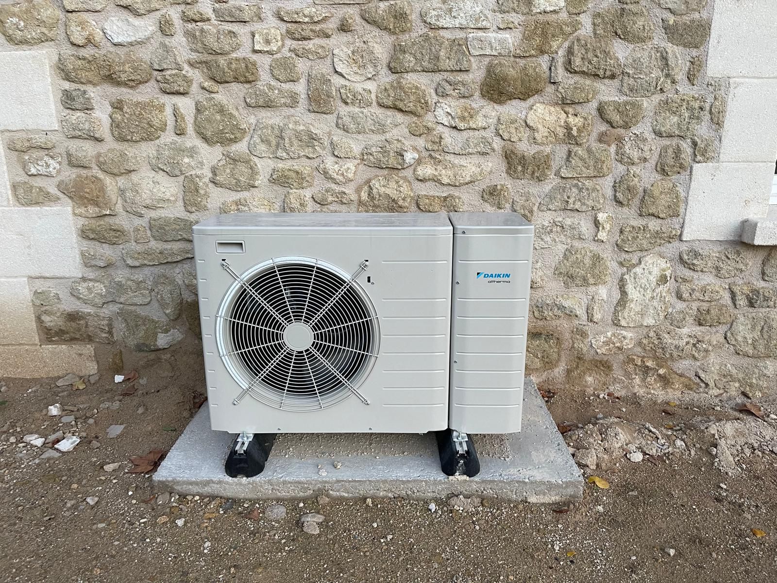 Climatiseur blanc monté au plafond, lumières encastrées et boiseries sur un plafond gris.