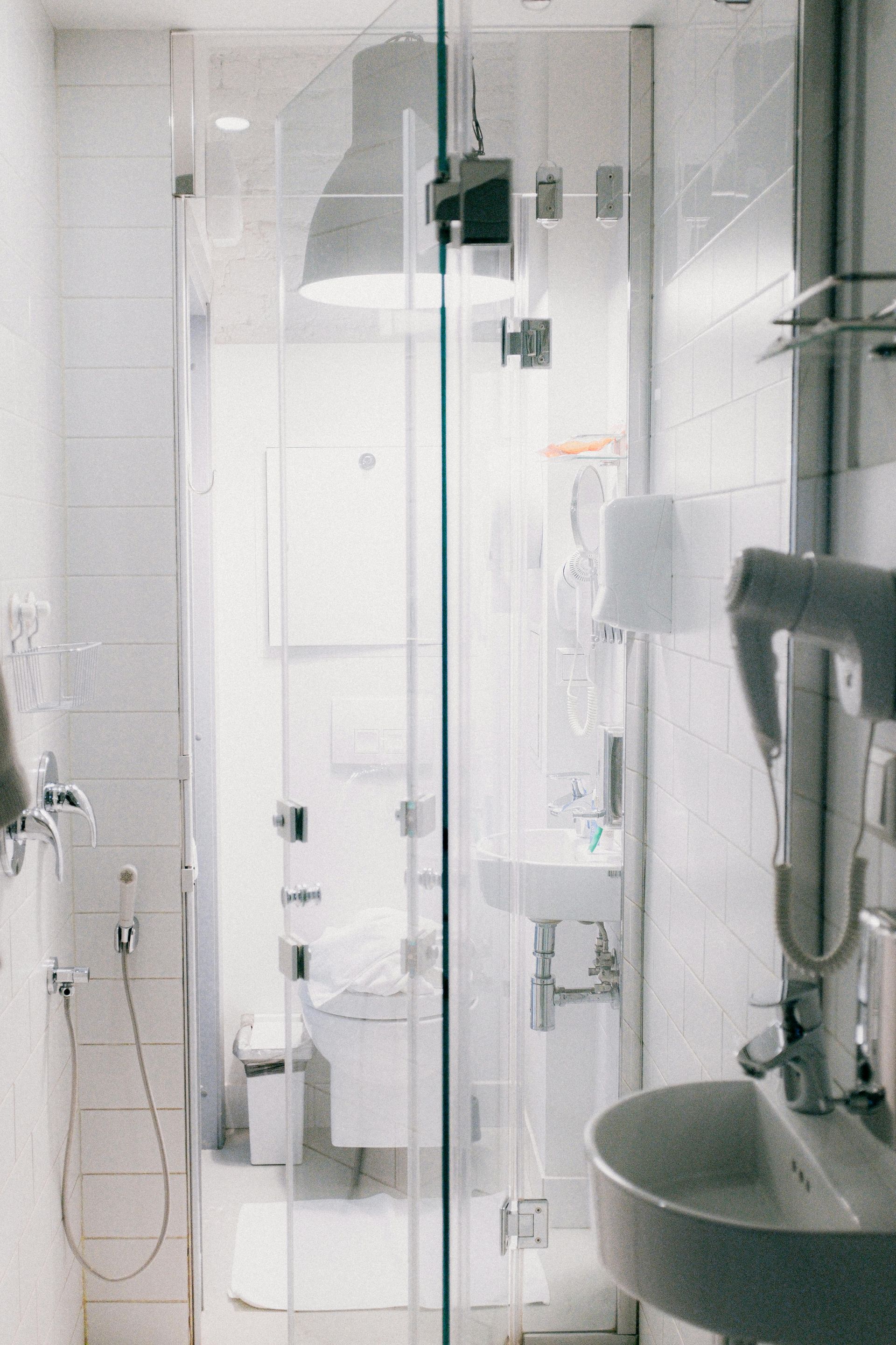 Robinetterie de salle de bain : lavabo, tuyauterie et baignoire blancs. Murs et sol couleur crème.