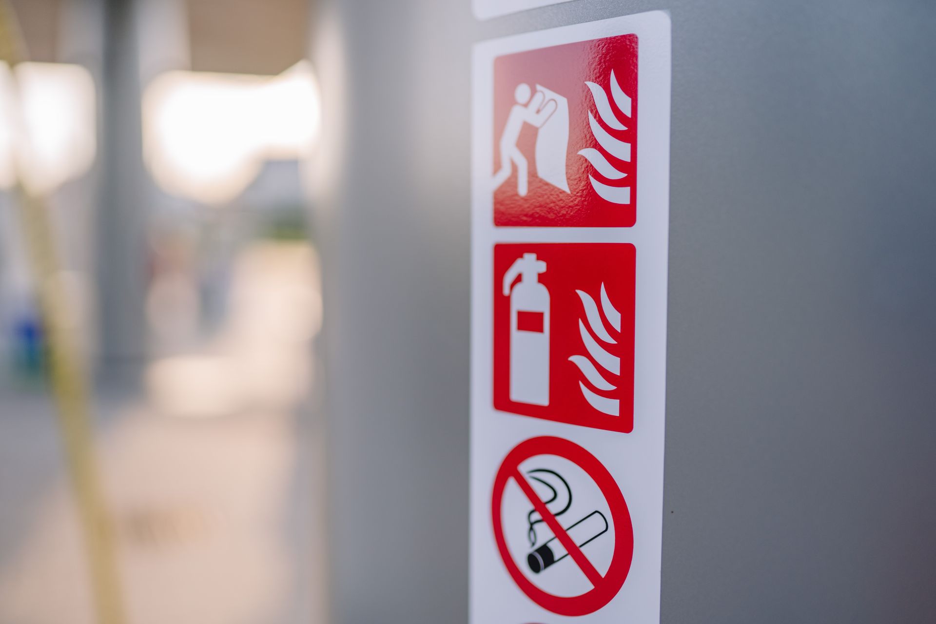 Panneau de sécurité rouge avec extincteur et interdiction de fumer sur un mur.