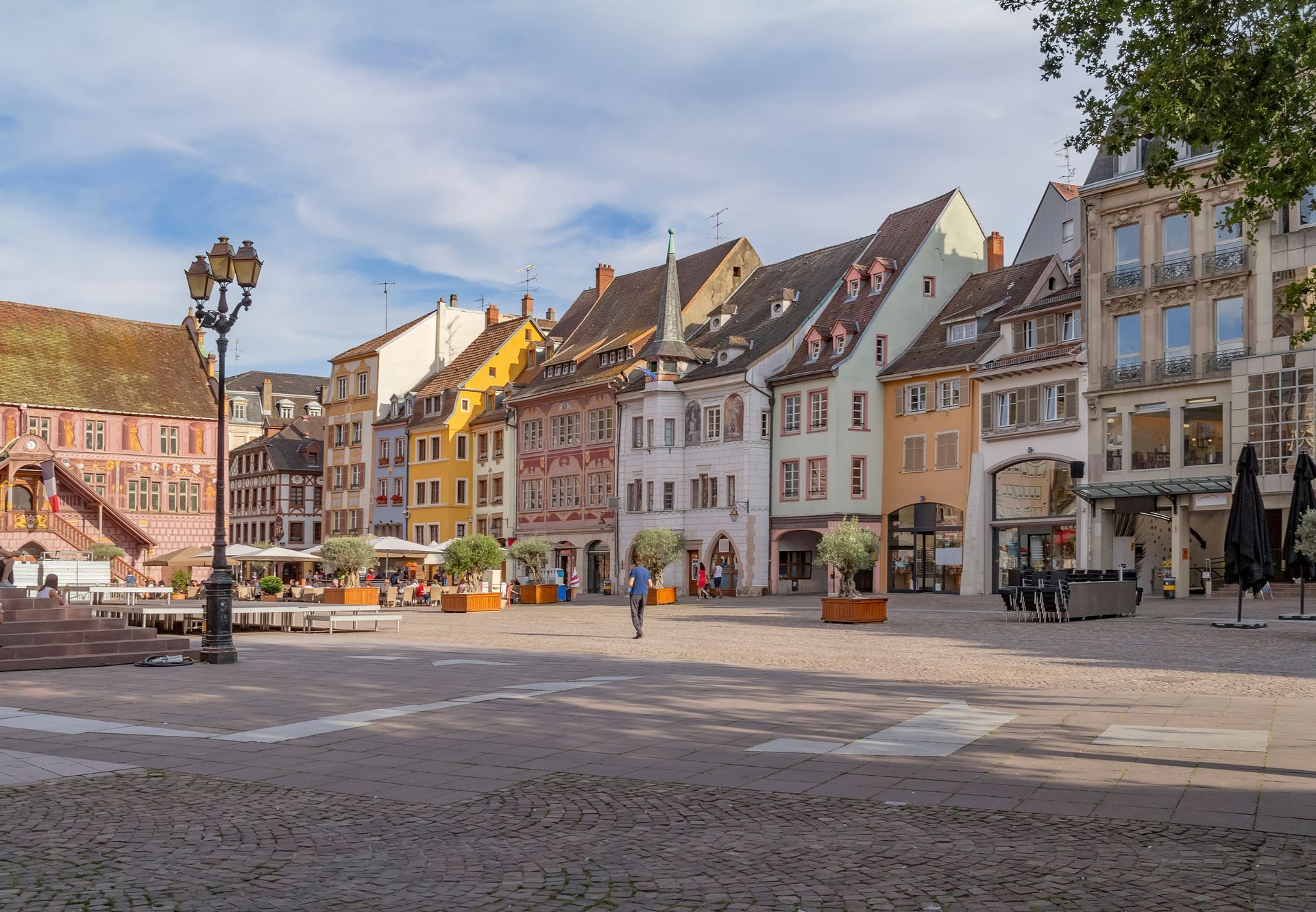 Place historique européenne avec ses maisons colorées et un lampadaire par une journée ensoleillée.