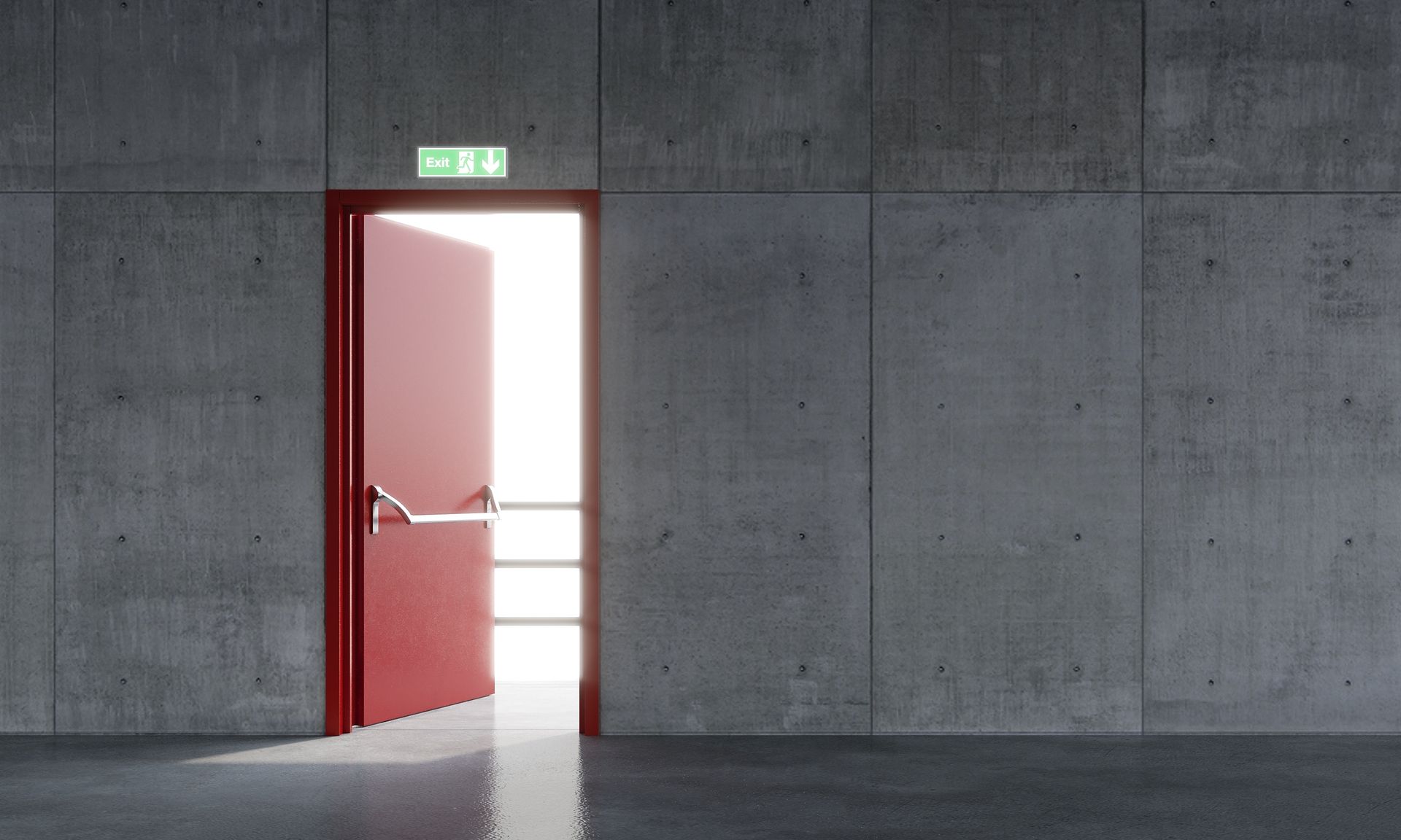 Porte rouge ouverte laissant entrer une lumière vive dans une pièce en béton gris.