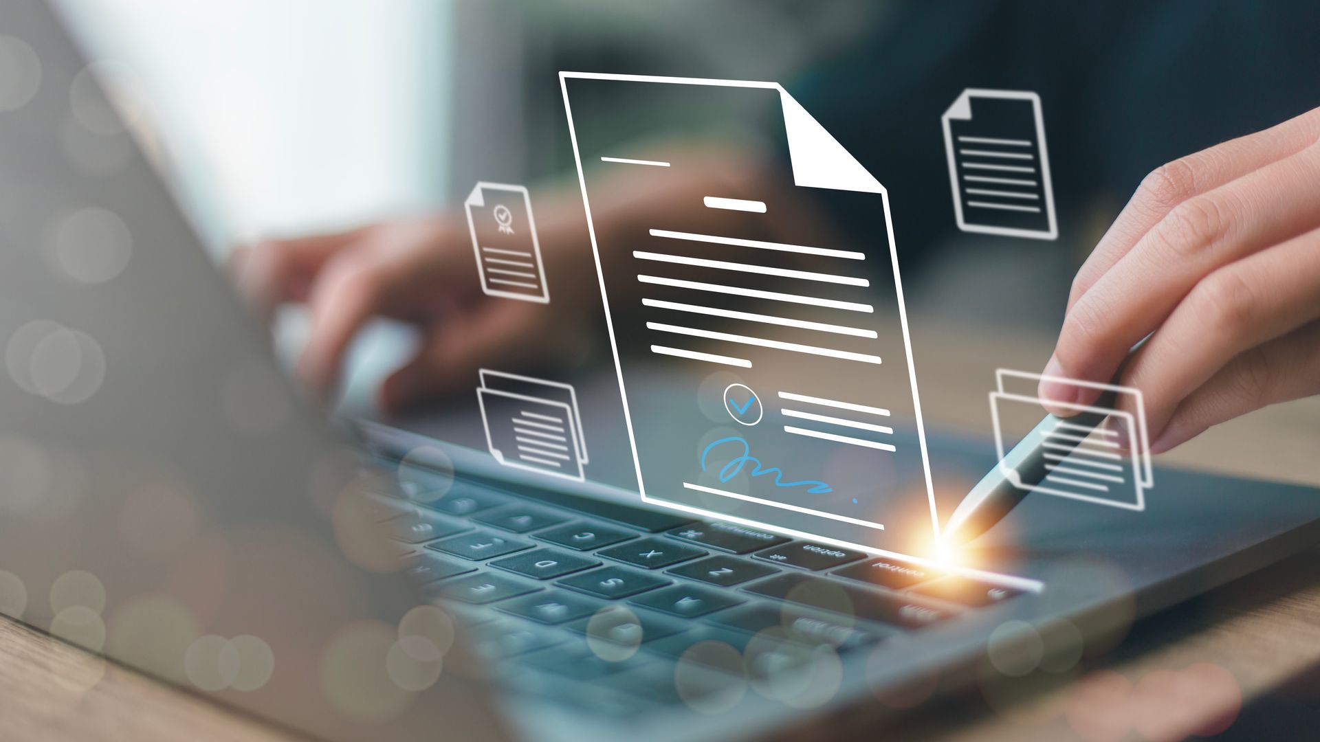Des mains tapent sur un ordinateur portable avec un document numérique lumineux et des icônes flottant au-dessus du clavier.