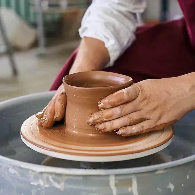 Una persona está haciendo una olla en un torno de alfarero.